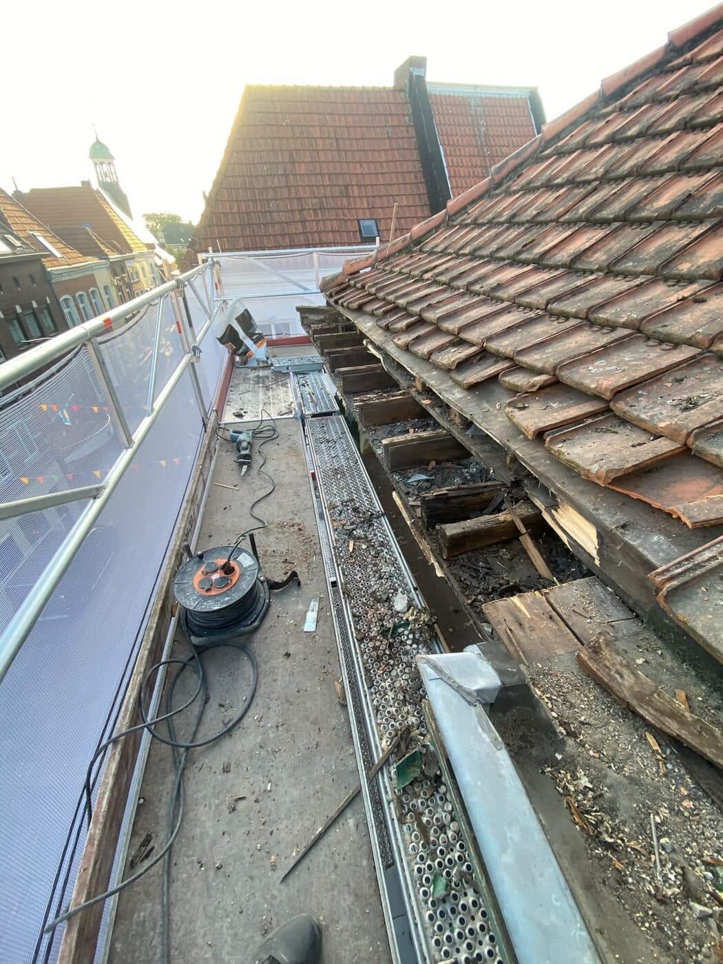 Hellend pannendak in renovatie, opgebouwd vanaf het dakbeschot met steiger
